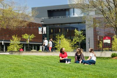 Student relaxing on the grass outside of the Science building